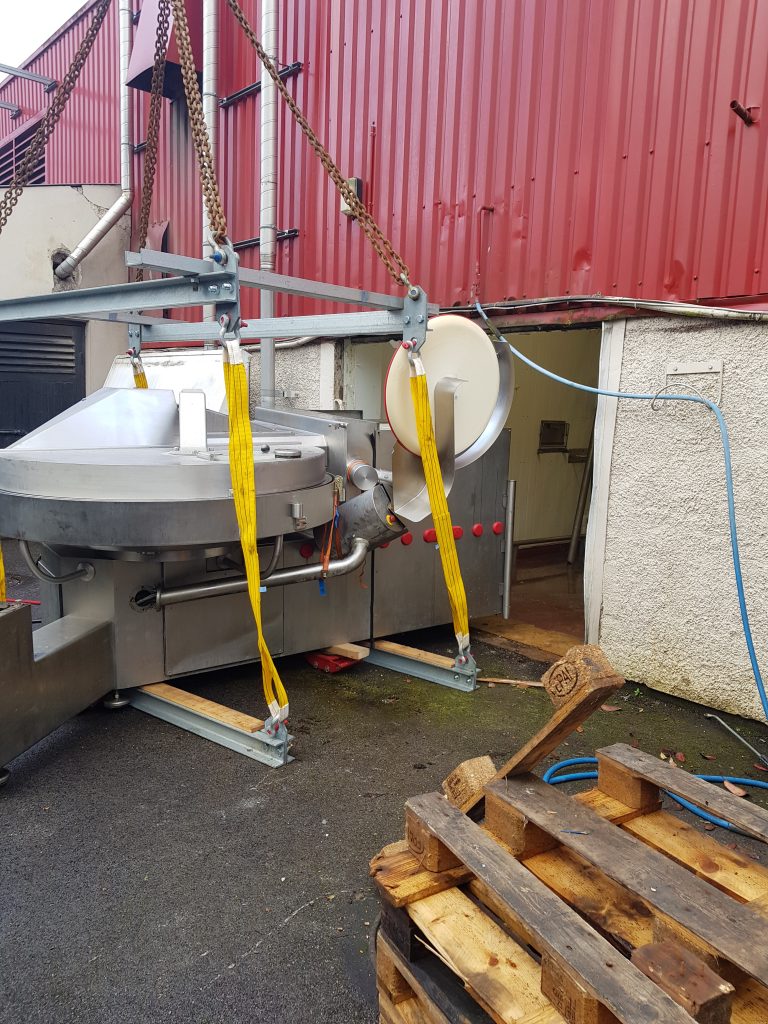 large item being loaded through the door of a factory using a truck mounted crane